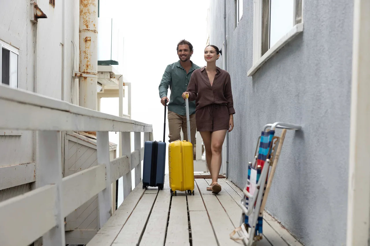 24 inch luggages being pushed by a tourist couple
