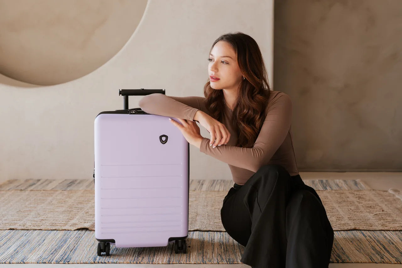 how to choose luggage hero image with a woman next to a pink traveler choice luggage markham set