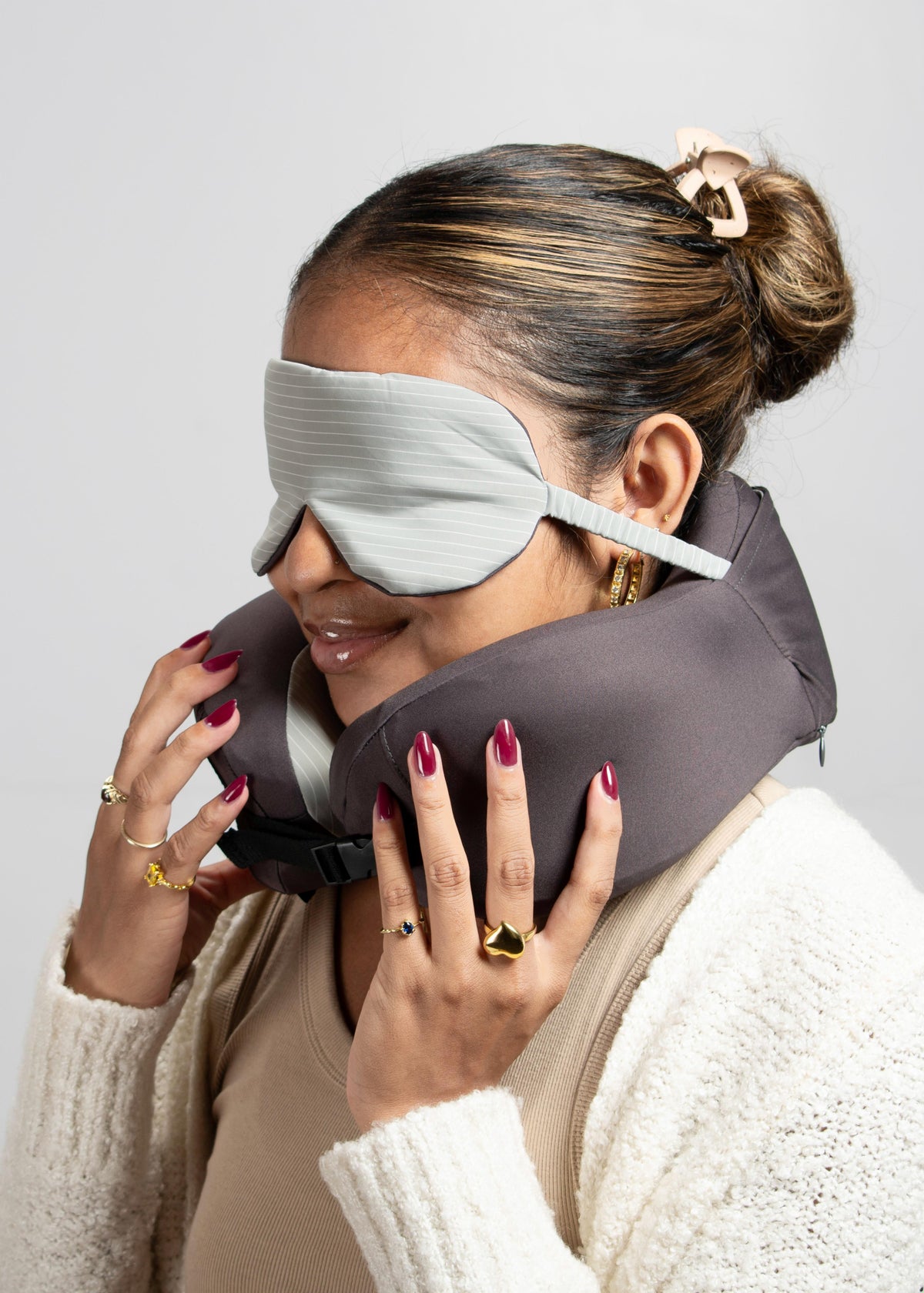 Woman wearing the travel pillow around her neck with the eye mask over her eyes