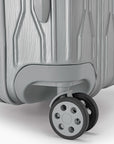 Close-up of a spinner wheel on a silver Bell Weather suitcase.