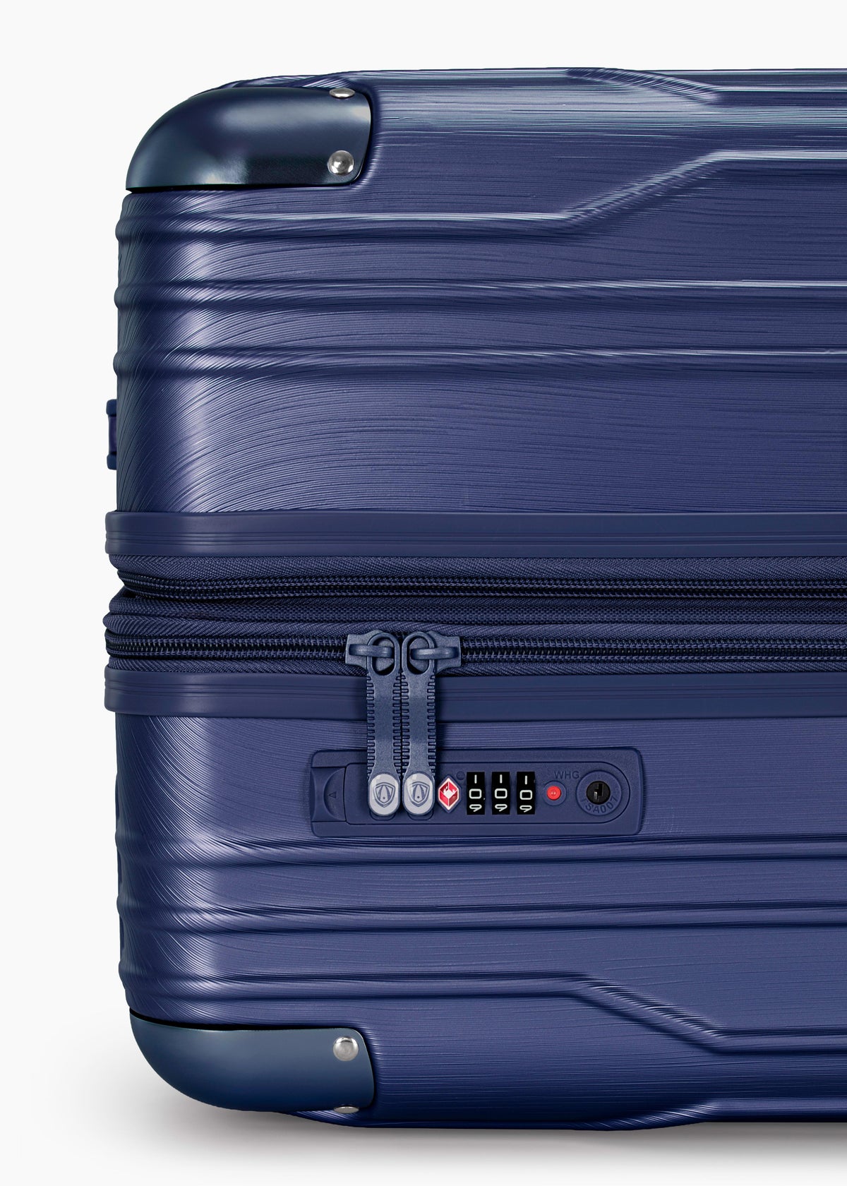 Close-up of the combination lock and zipper pulls on a navy Bell Weather carry-on.