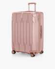 Angled front view of a rose gold Bell Weather large checked suitcase with its telescoping handle extended.
