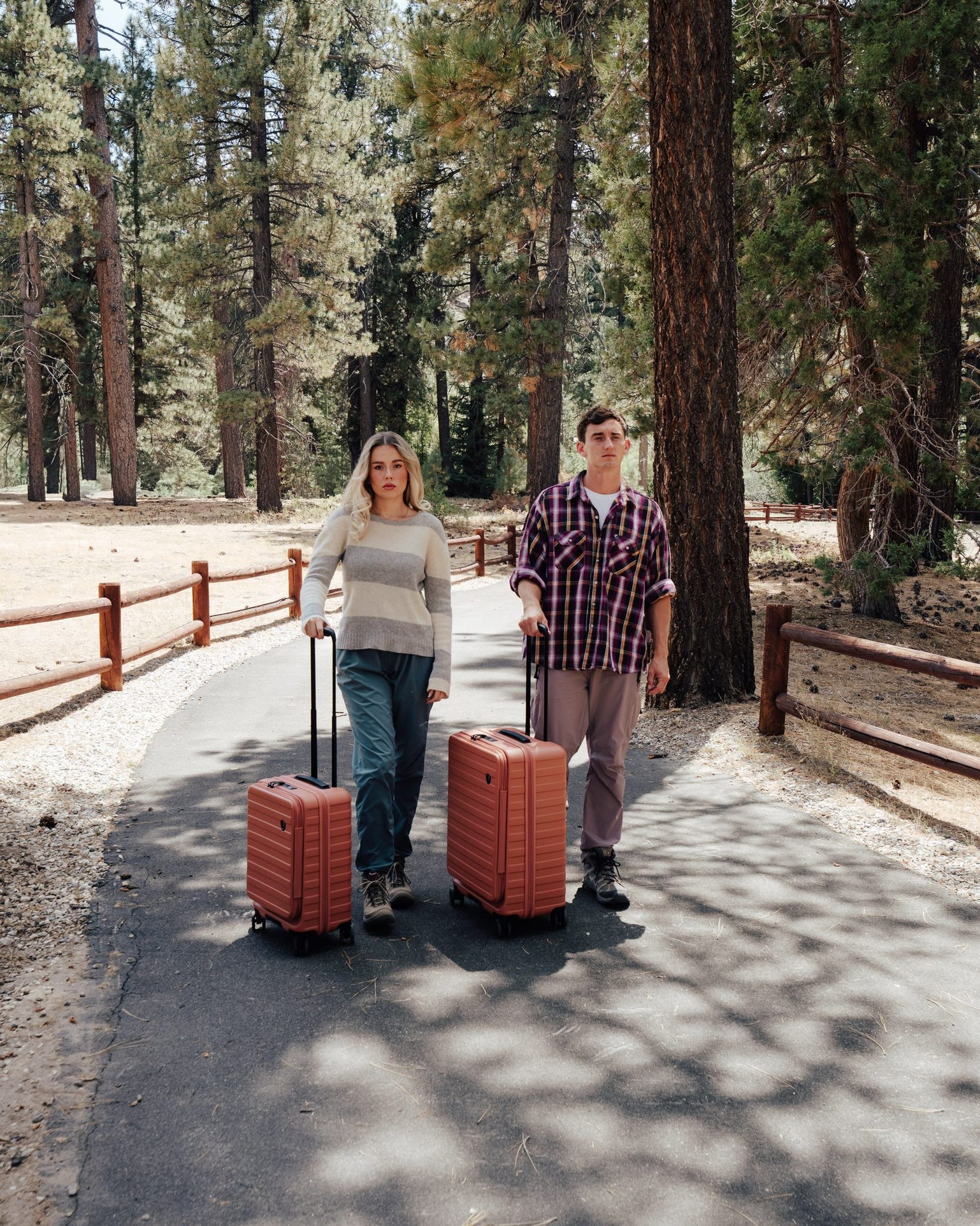 Couple walking two orange Novia spinners down a paved forest trail