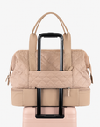 Rear luggage loop of the beige Weekender Bag around a suitcase handle