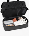 Black Weekender Bag with the lower compartment open and packed with travel items
